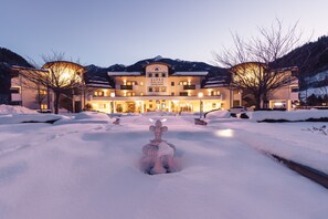 A hotel with a central fountain, snow-covered surroundings, and a mountainous backdrop. - Alpenpalace Luxury Hideaway & Spa Retreat (Valle Aurina)