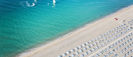 Privatstrand, Liegestühle, Sonnenschirme, Windsurfen