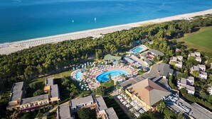An aerial view of a resort with a beach, swimming pools, and a large building with multiple floors. - Serenè Resort (Cutro)