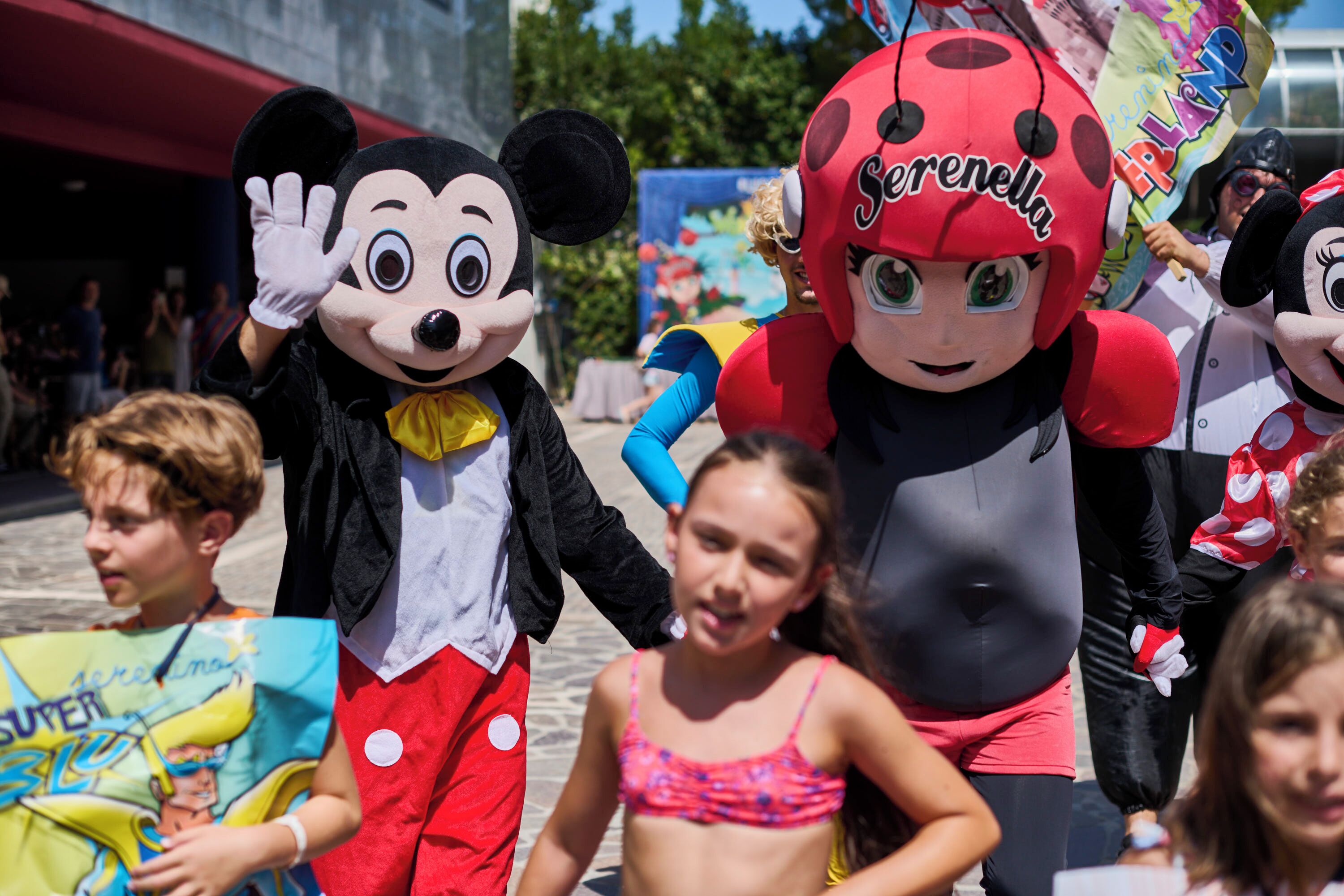 A character in a red and black costume with a name tag.