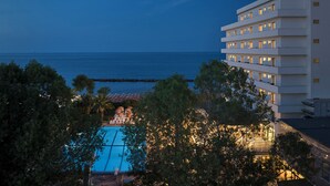 A modern hotel with a pool, surrounded by trees and overlooking a beach. - Serena Majestic Hotel (Montesilvano)