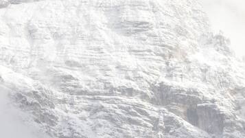 Een met sneeuw bedekte berg met een ruig, rotsachtig oppervlak.