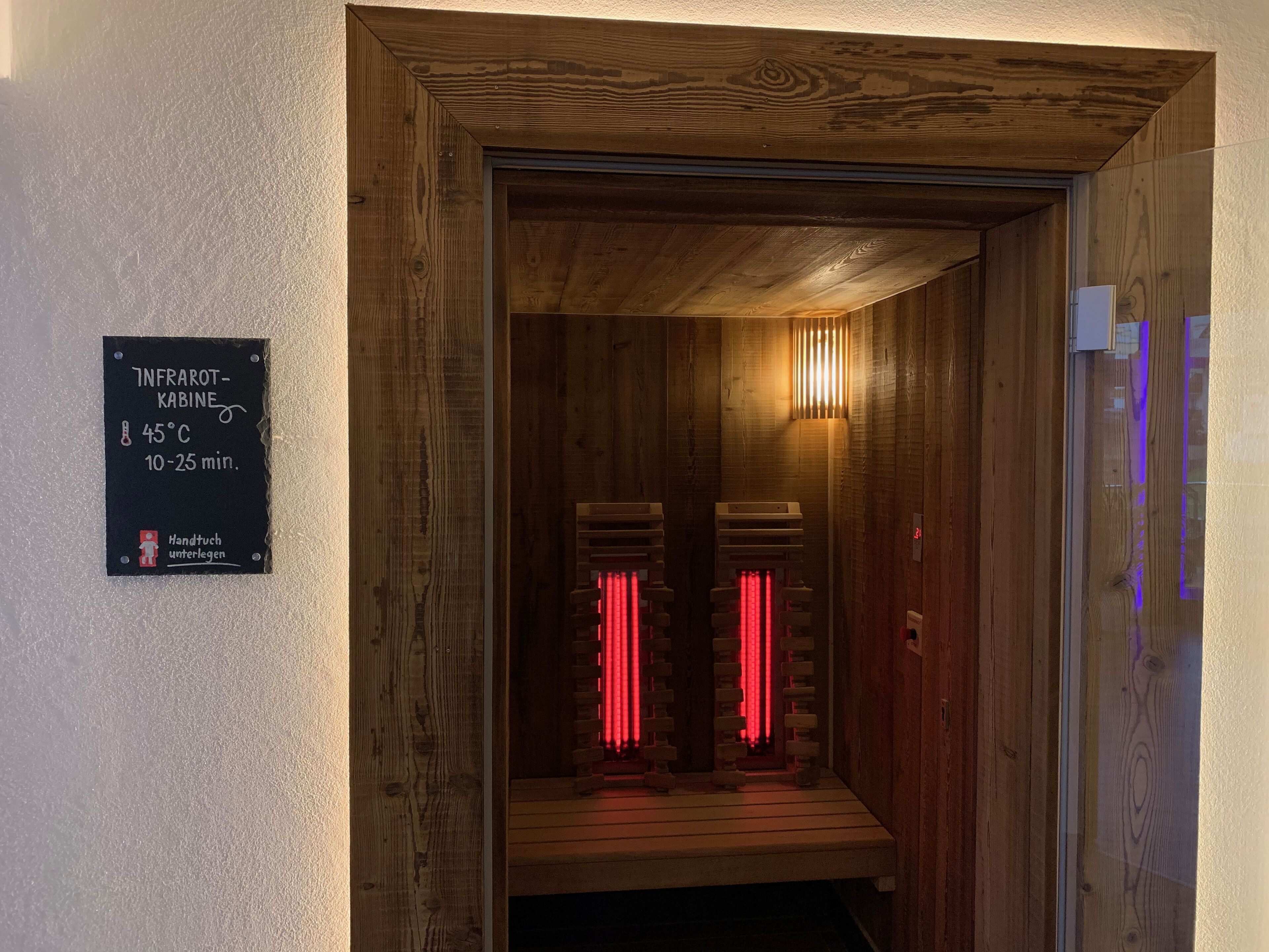 A wooden sauna with a sign indicating temperature and duration.