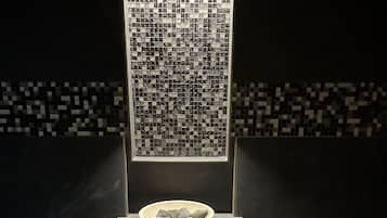 Features a sleek, contemporary bathroom with a rectangular mirror and mosaic-patterned floor.