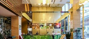 A hotel lobby with a reception desk, a staircase, and a large window offering a view of the street. - Shanshui Trends Hotel LuoHu ShenZhen (Shenzhen)