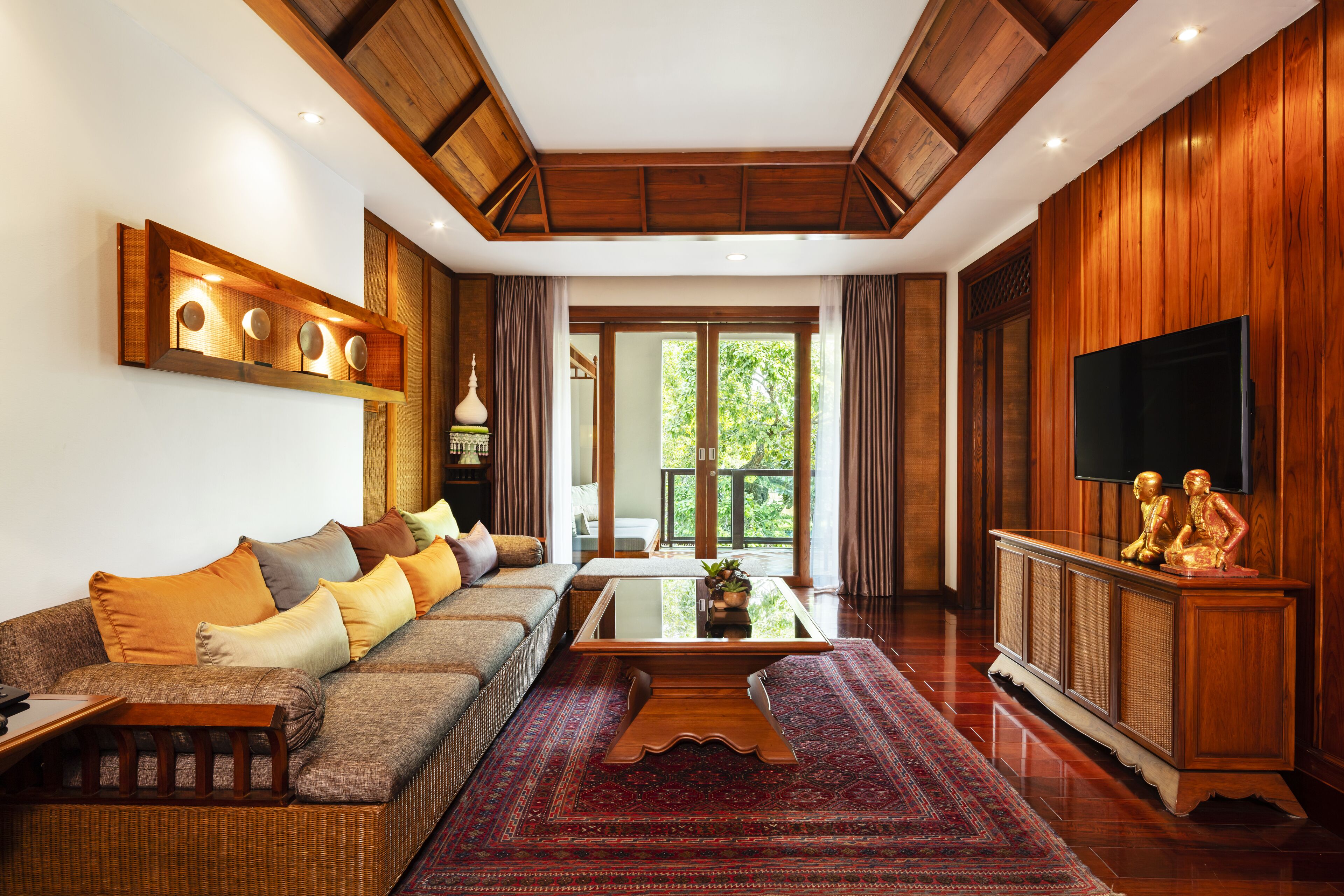 Un salón espacioso con un sofá grande, una mesa de centro y un televisor sobre un mueble de madera.