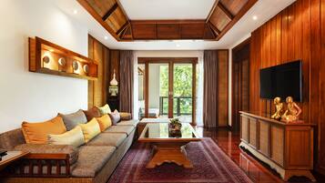 Un salón espacioso con un sofá grande, una mesa de centro y un televisor sobre un mueble de madera.