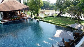 A swimming pool with a patio area and lounge chairs.