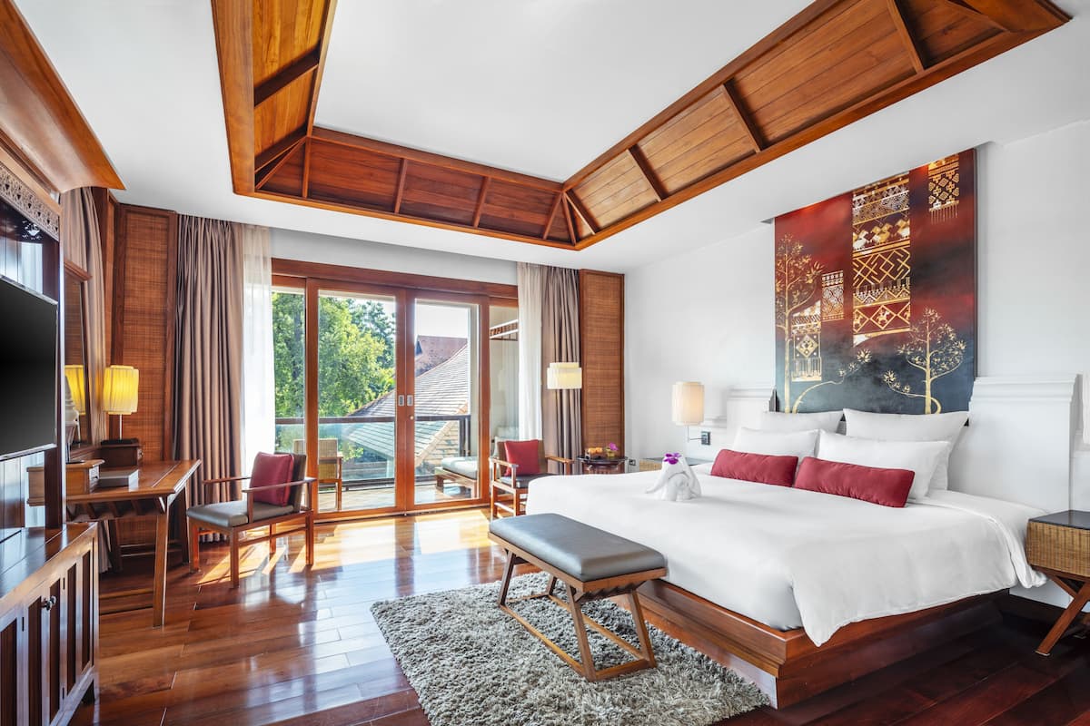 Um quarto espaçoso com uma cama grande, teto de madeira e vista para o exterior.