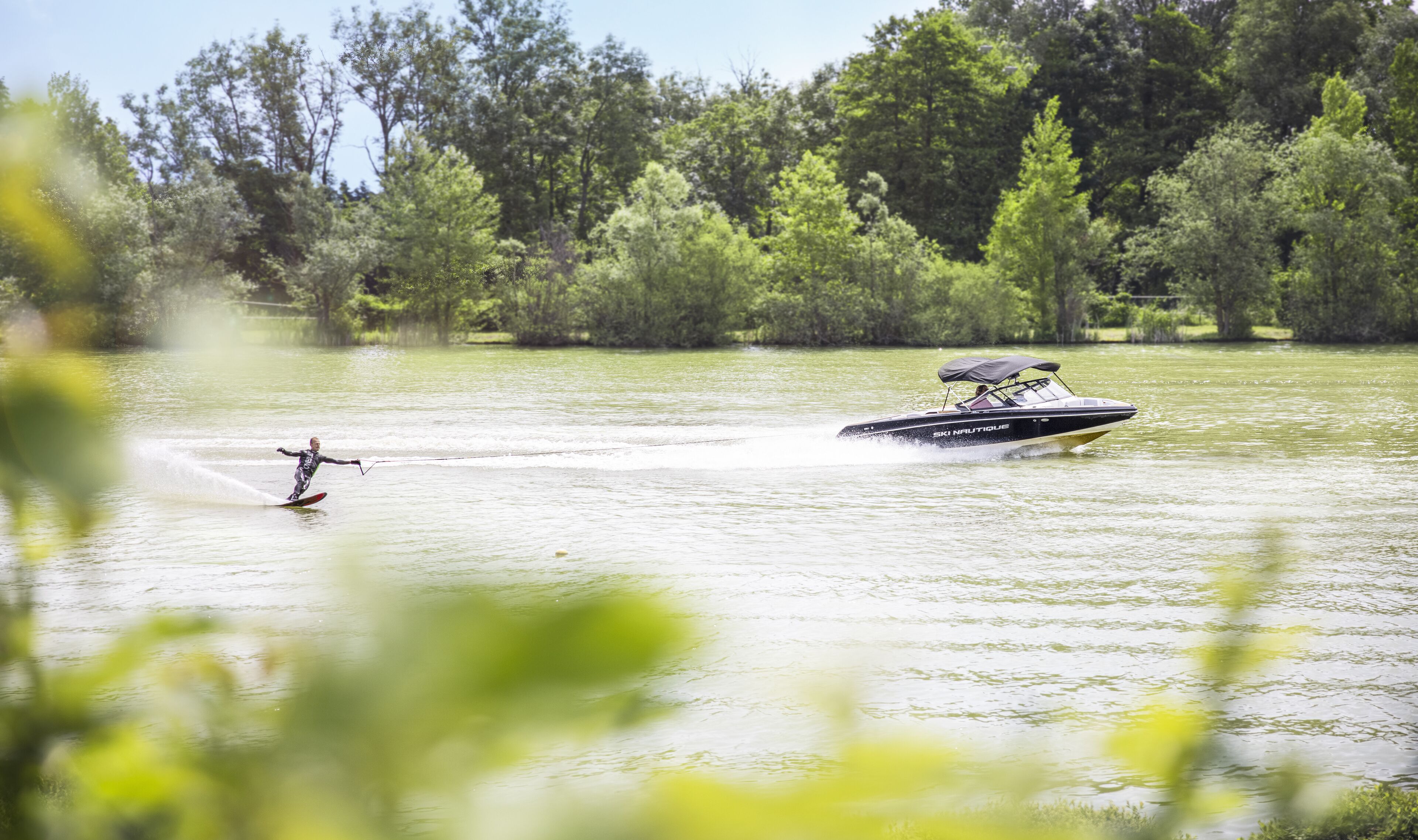 Watersportactiviteit met een boot en een wakeboarder.