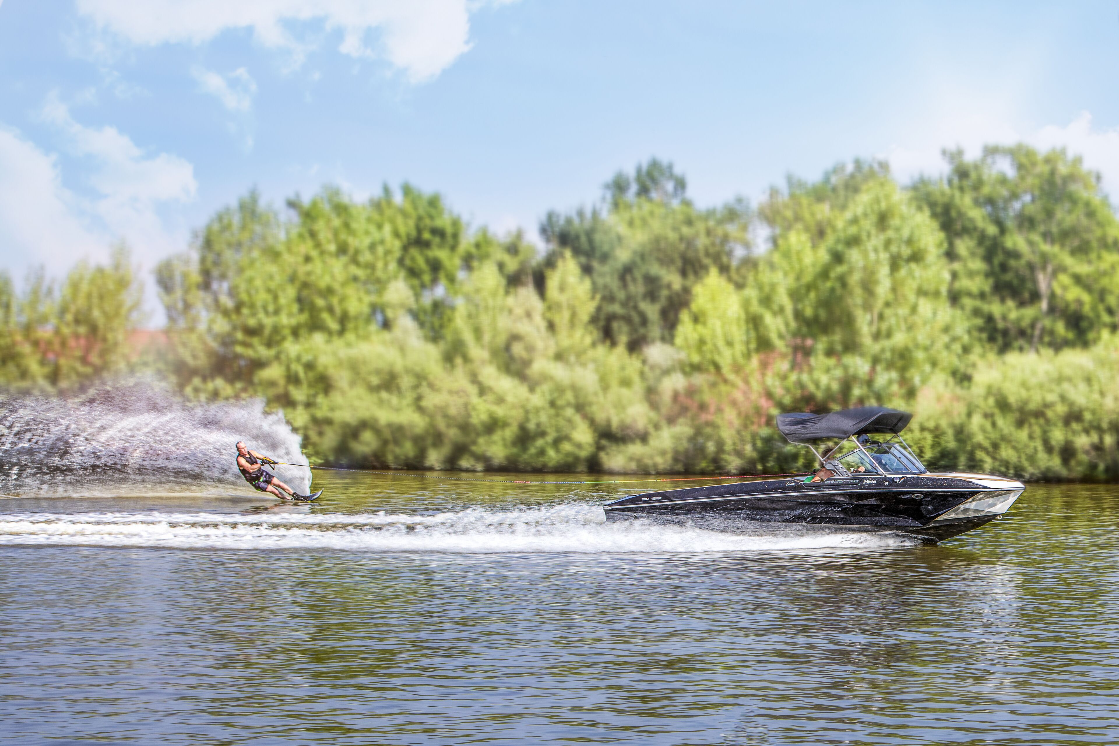 Een watersportactiviteit met een wakeboarder en een boot op een meer.
