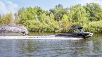 Een watersportactiviteit met een wakeboarder en een boot op een meer.