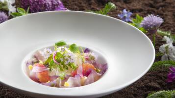 A white bowl of colorful salad with various vegetables and herbs.