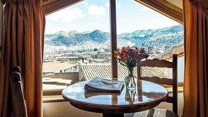 A room with a large window offering a view of a mountainous landscape. - Casa San Blas Boutique Hotel (Cusco)