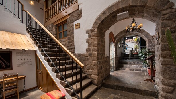 A stone staircase with a wooden railing leading to a balcony. - Casa San Blas Boutique Hotel (Cusco)