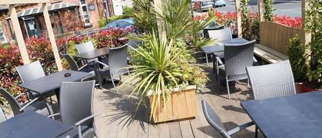 Una terrazza esterna con mobili in vimini e piante in vaso.