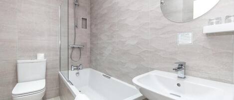 Un baño moderno con inodoro, bañera y lavabo.