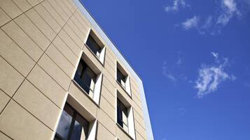 A modern building with a geometric facade and multiple windows.