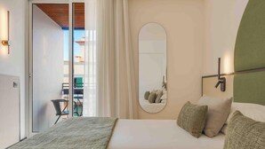 Un dormitorio con cama, espejo y vistas a un balcón.