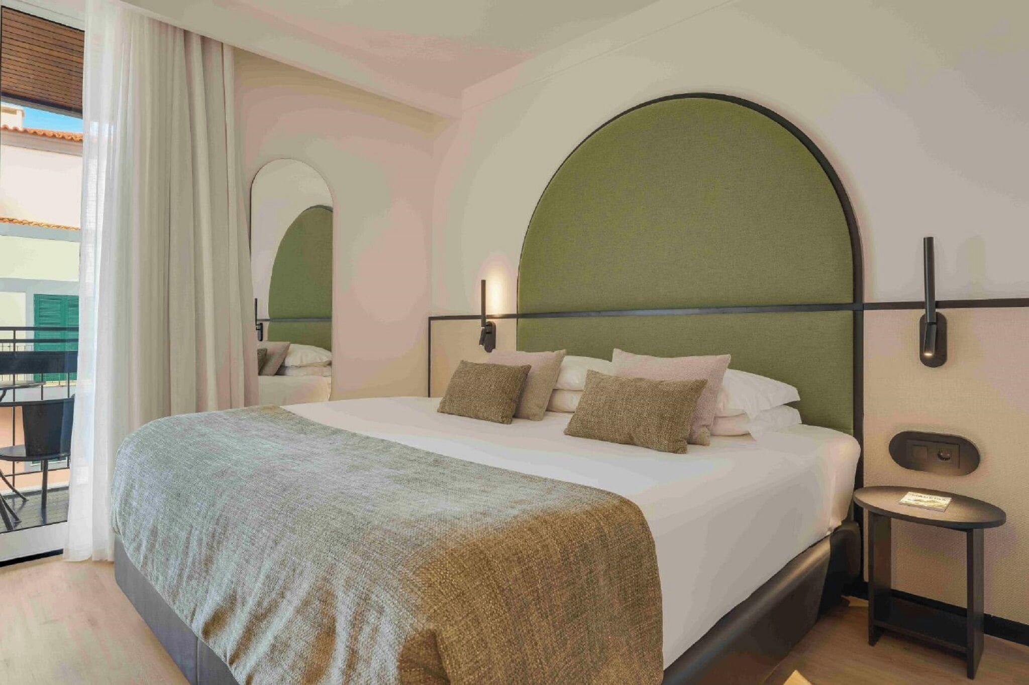Une chambre d’hôtel avec un grand lit, une petite table et une vue sur l’espace extérieur.