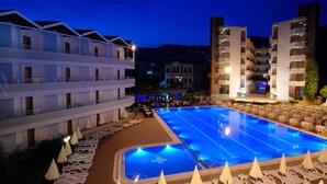 Ein Hotel mit großem Hallenbad, mehreren Balkonen und Liegestühlen.