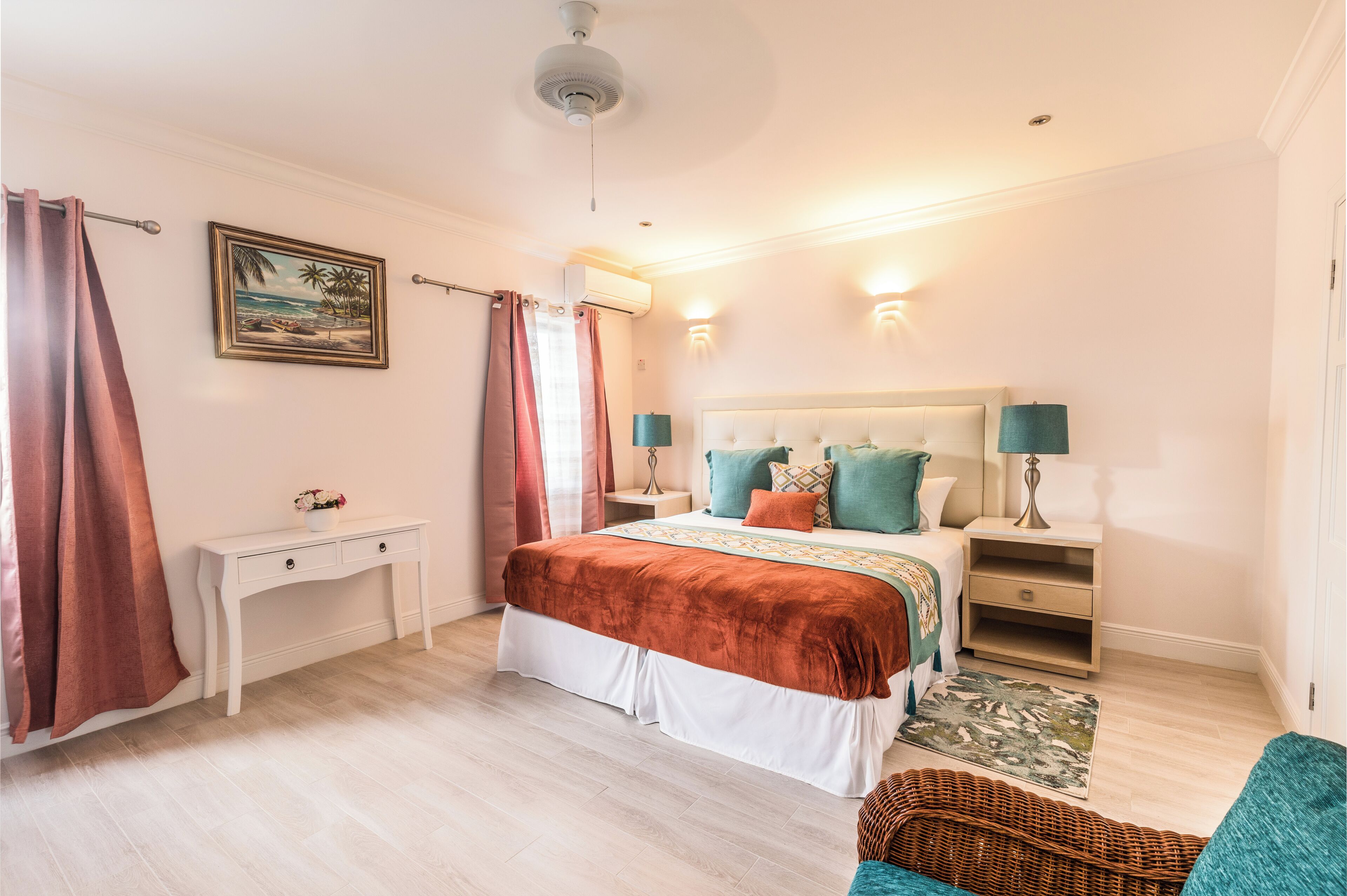 A bedroom with a bed, bedside tables, a desk, and a chair.
