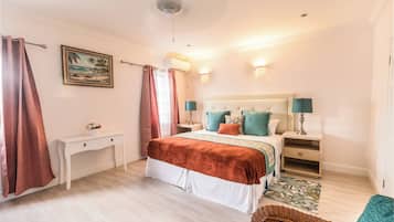 A bedroom with a bed, bedside tables, a desk, and a chair.