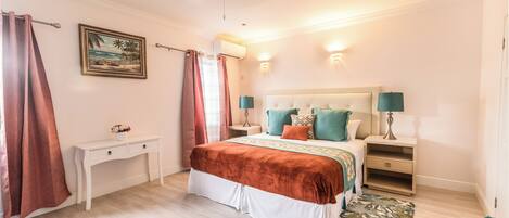 A bedroom with a bed, bedside tables, a desk, and a chair.