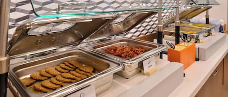 Un buffet avec des récipients étiquetés contenant des saucisses de dinde et des biscuits.