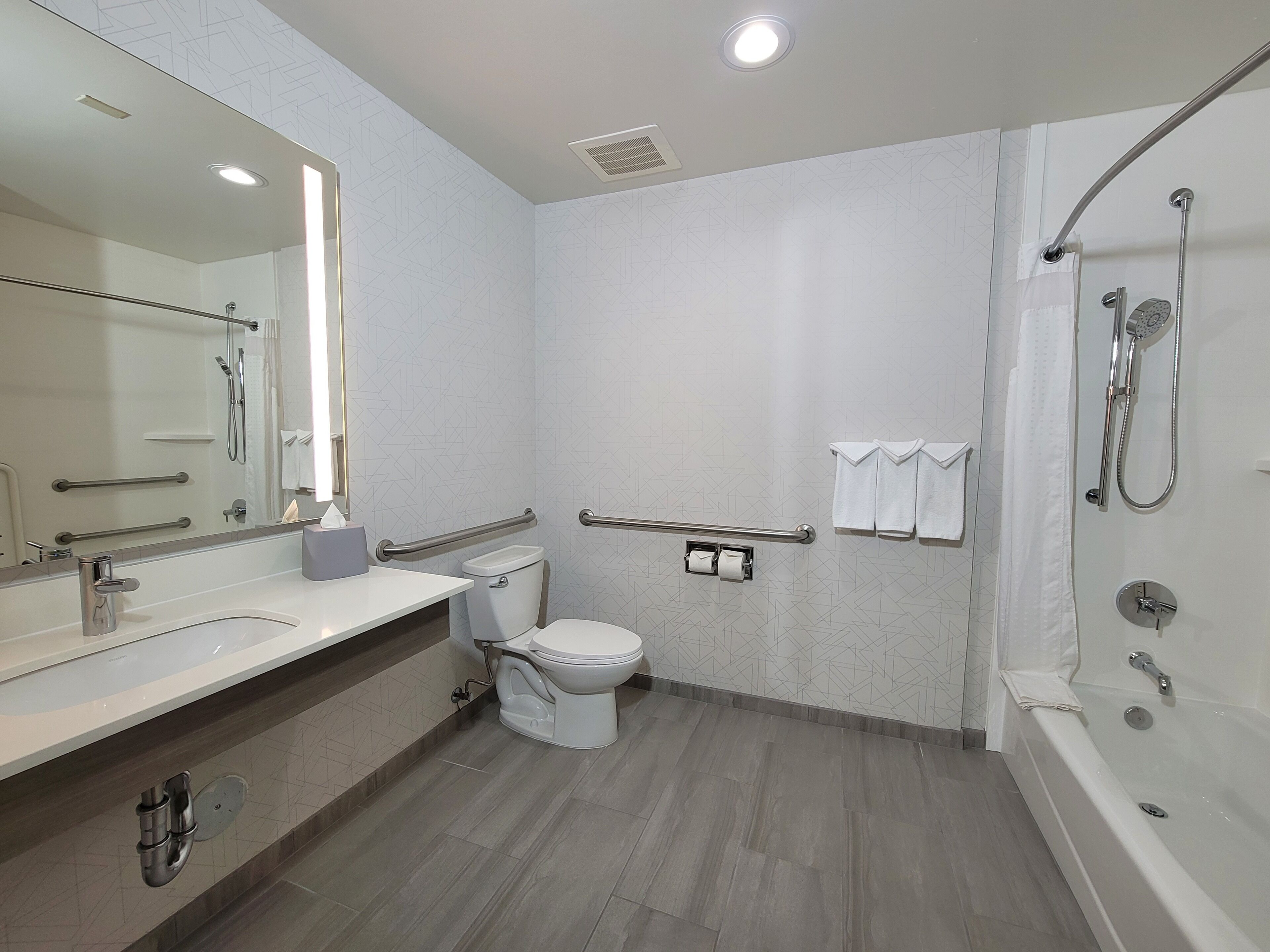 Un baño moderno con ducha, inodoro y lavamanos.