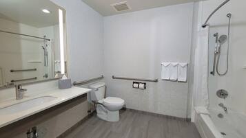 Un baño moderno con ducha, inodoro y lavamanos.