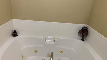 A white bathtub with a single faucet, two soap dishes, and a towel rack.