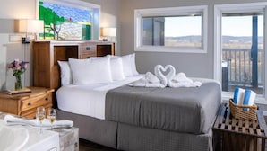 Habitación de hotel con una cama grande, una bañera y vistas al exterior.