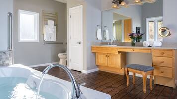A modern bathroom with a bathtub, vanity, and a wooden bench.