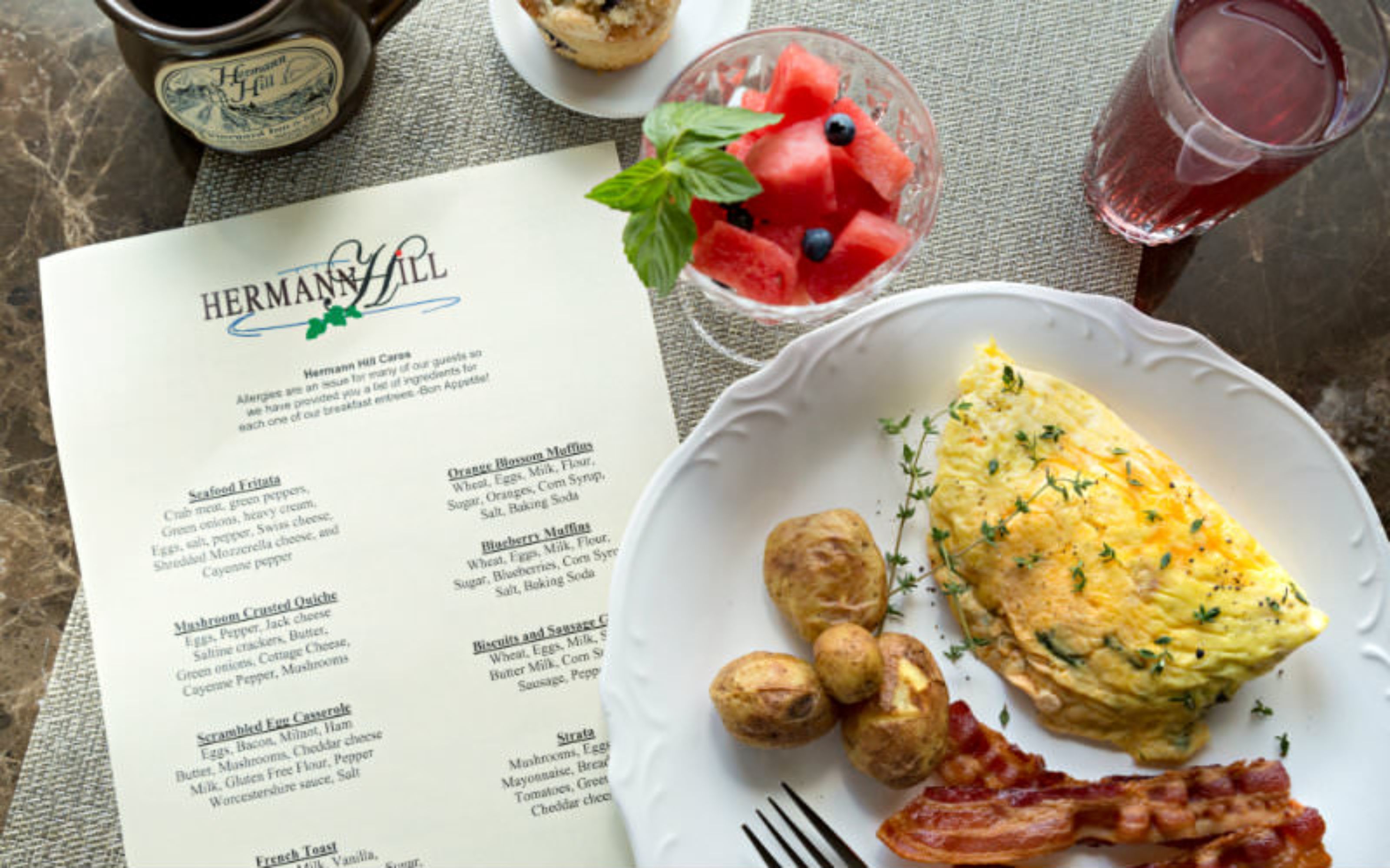 Um menu intitulado 'HERMANN HILL' com itens de café da manhã, como ovos mexidos e muffins.
