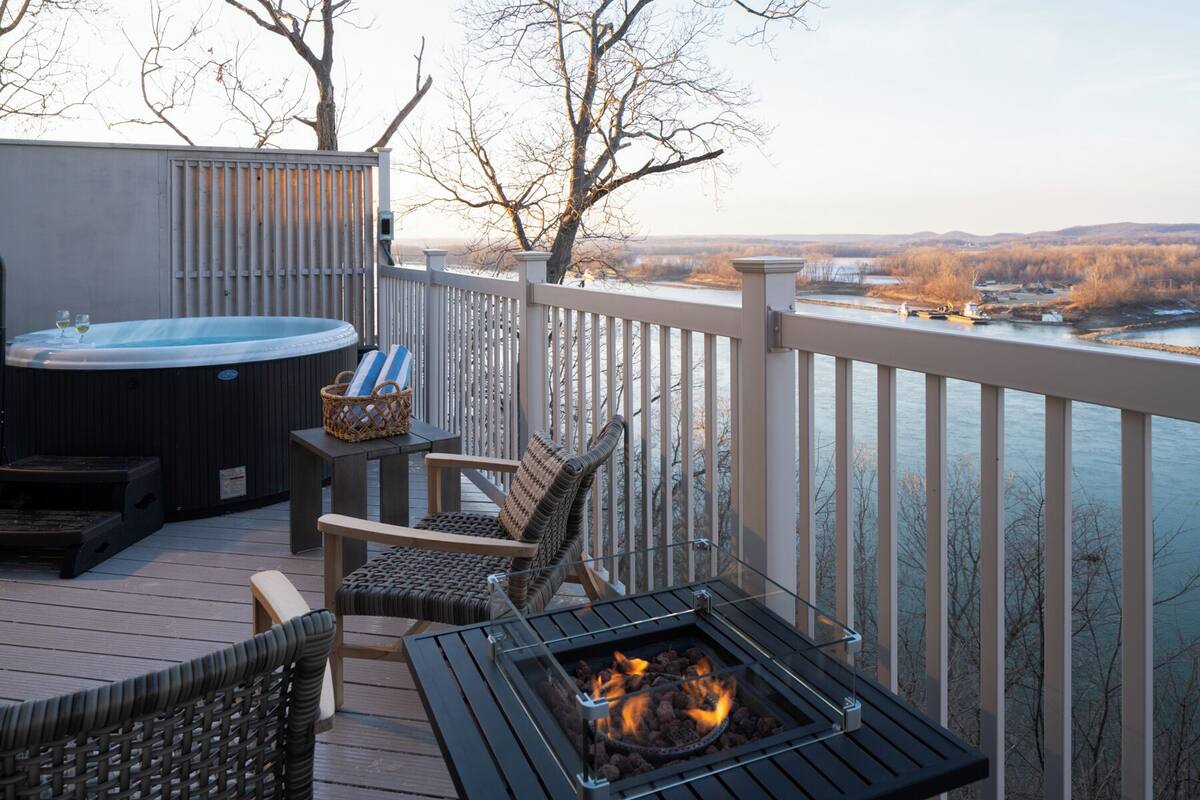 Una terraza con jacuzzi, asientos al aire libre y una chimenea.