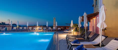 Piscine extérieure, parasols de plage, chaises longues
