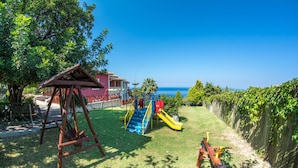 Un parque infantil con columpios, tobogán y zona de escalada.