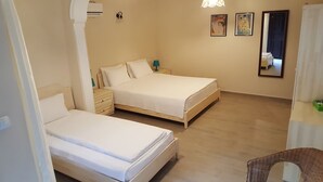 A hotel room with two single beds, a small bedside table with a lamp, a wall-mounted air conditioner, and two framed artworks. - Hotel Villa Monte (Kemer)