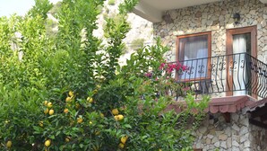 A stone building with a balcony featuring a wrought iron railing. - Hotel Villa Monte (Kemer)