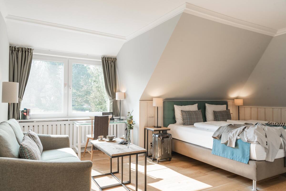 Ein modernes Schlafzimmer mit einem Bett, einem Schreibtisch und einem Fenster.