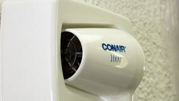 A white wall-mounted hair dryer with the brand name CONAIR and model number 1600.