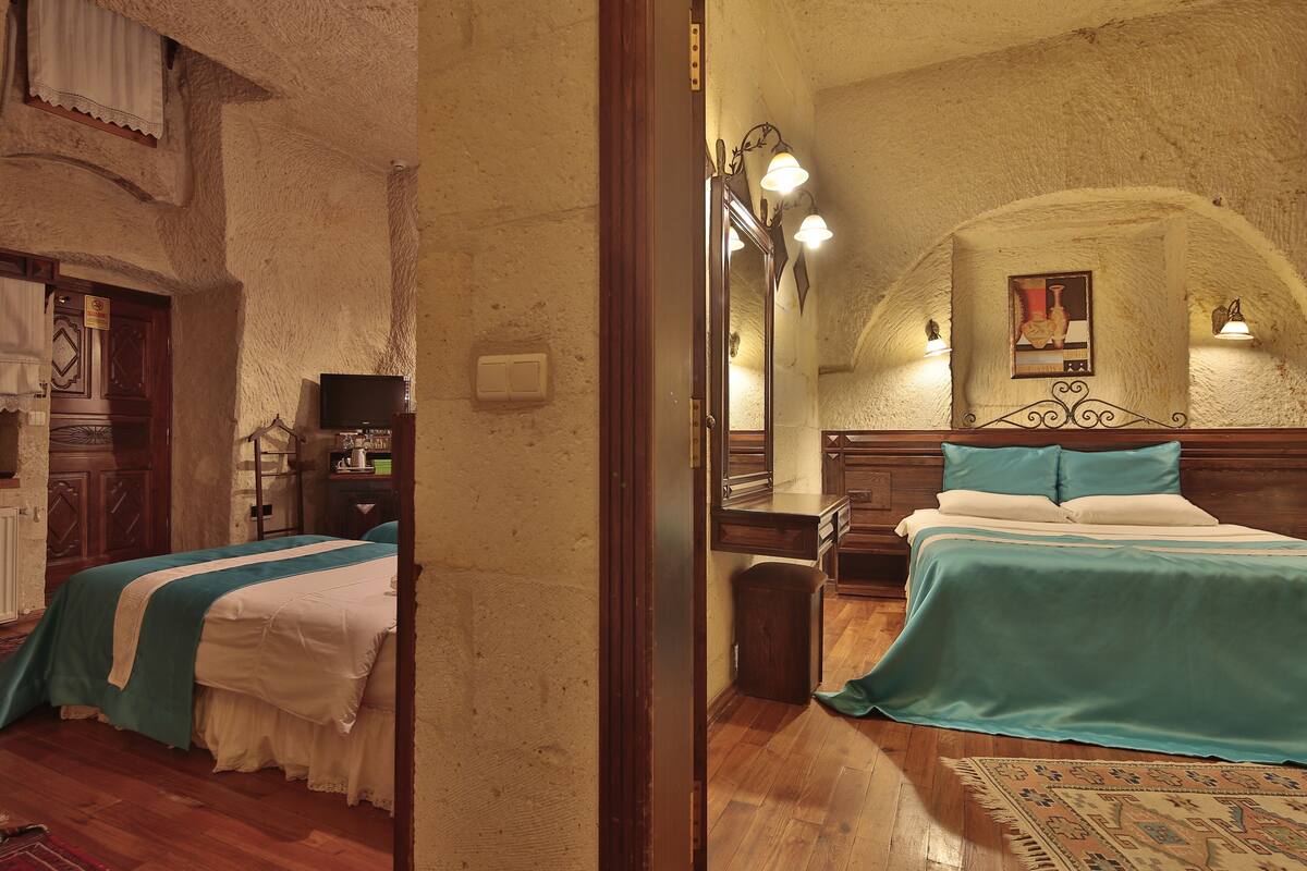 Ein Schlafzimmer mit einem hölzernen Bett, einem Nachttisch, einem Spiegel und einer Wandleuchte.