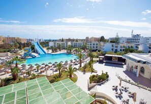 A resort with a large swimming pool, a water slide, and multiple sun loungers. - Soviva Resort - Families Only (Port El Kantaoui)