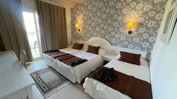 Habitación triple | Minibar y ropa de cama