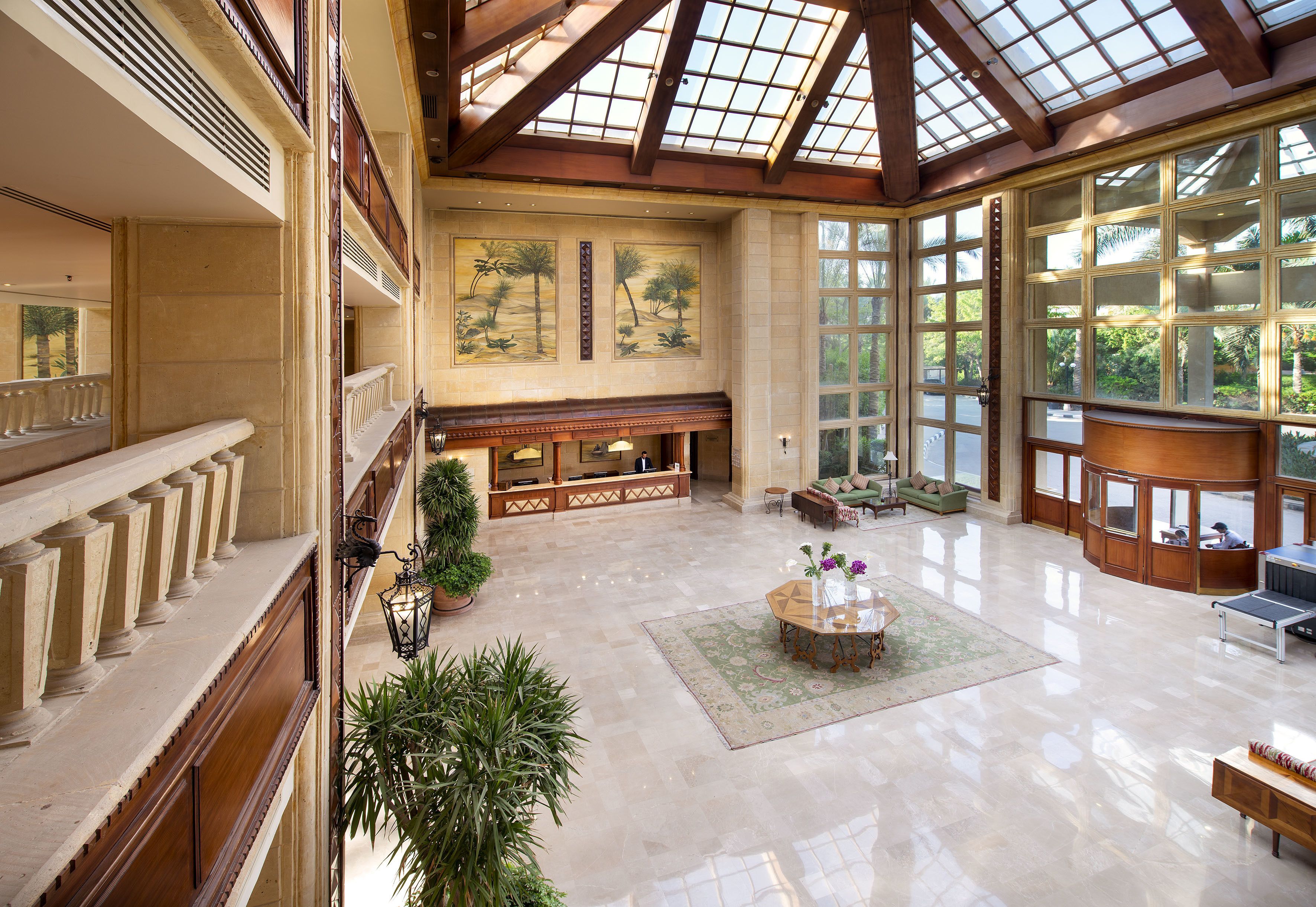 A spacious lobby with a high ceiling, large windows, and a central seating area.