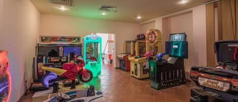 Une salle d’arcade intérieure proposant divers jeux, notamment des jeux de course et des jeux sur le thème de l’automobile.