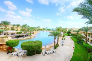 Una piscina techada, una piscina al aire libre, sombrillas