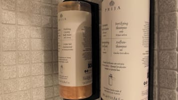 Twee shampoo flessen bevestigd aan een structuurwand.