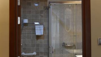 A bathroom with a glass shower enclosure, a toilet, a sink, and a towel rack.